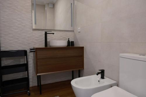 a bathroom with a white toilet and a sink at Refúgio da Barrinha in Praia de Mira