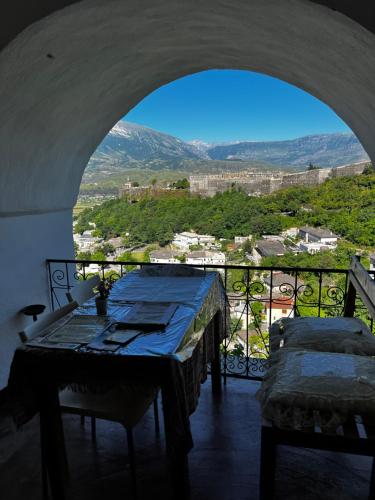 a room with a table and a balcony with a view at Guest House Salaria in Gjirokastër