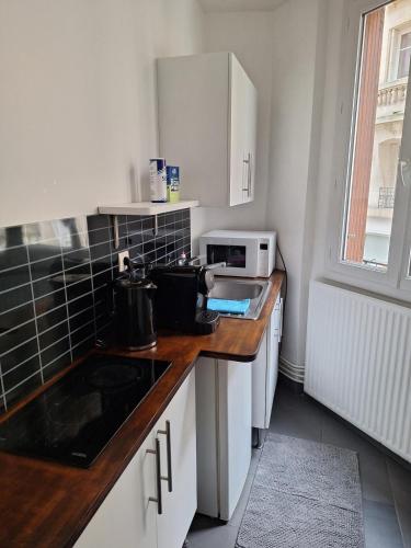 une cuisine avec un évier et un micro-ondes dans l'établissement Charming apartment in the heart of Paris, à Paris