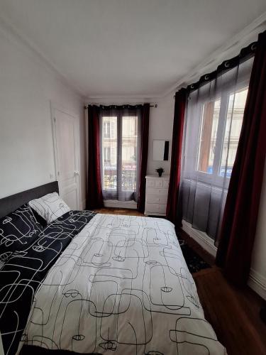 une chambre avec un grand lit et deux fenêtres dans l'établissement Charming apartment in the heart of Paris, à Paris