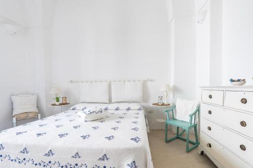 a white bedroom with a bed and a dresser at La dimora del pescatore in Porto Cesareo