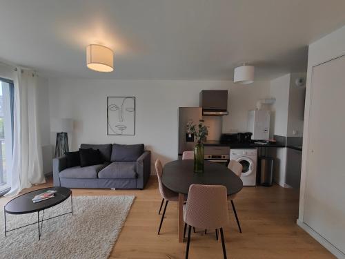 un salon avec une table et un canapé dans l'établissement Le Quai des Verts, à Caen