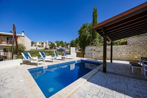 a swimming pool with chairs and a pavilion at Stroumpi Private Pool Villa in Stroumbi