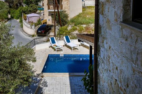 a swimming pool with two lounge chairs next to a building at Stroumpi Private Pool Villa in Stroumbi