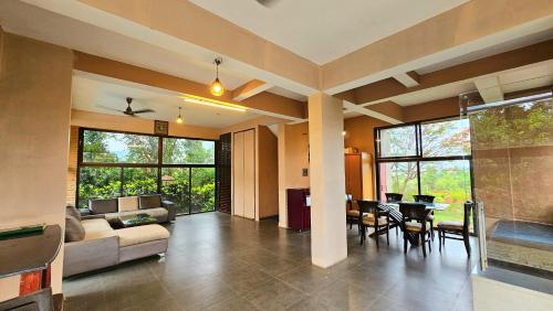 a living room with a couch and a table at Elephant House Luxury Villa with Curve Pool-Colossal Garden-Panoramic View in Lonavala