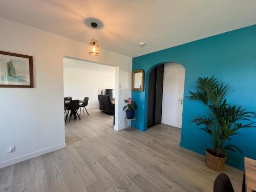 un salon avec des murs bleus et une plante en pot dans l'établissement Le logis de Keramporchet - Proche plages, à PloÃ©ven