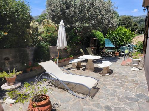 un patio avec une table, un parasol et des chaises dans l'établissement L'arche en rez de jardin de villa à Toulon, à Toulon