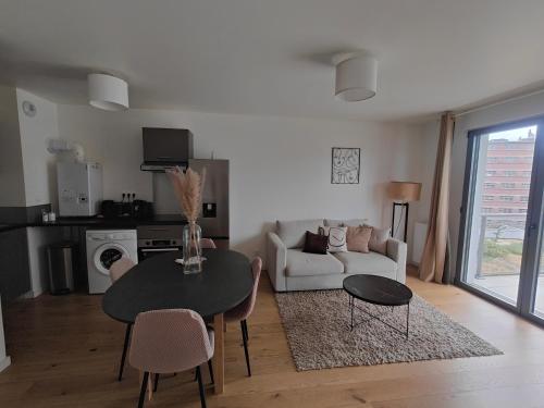 un salon avec une table et un canapé dans l'établissement Le Quai des Bleus, à Caen