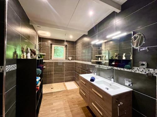 une salle de bain avec un lavabo et un grand miroir dans l'établissement Villa Provence 70, à LʼIsle-sur-la-Sorgue