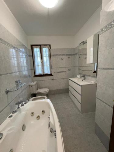 a bathroom with a tub and a toilet and a sink at Villa Ondina Versilia in Lido di Camaiore