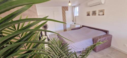 - un lit dans une chambre avec une plante dans l'établissement Maison à louer, à Narbonne