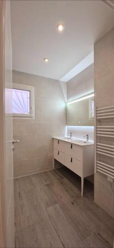 une salle de bain blanche avec un lavabo et un miroir dans l'établissement Maison à louer, à Narbonne