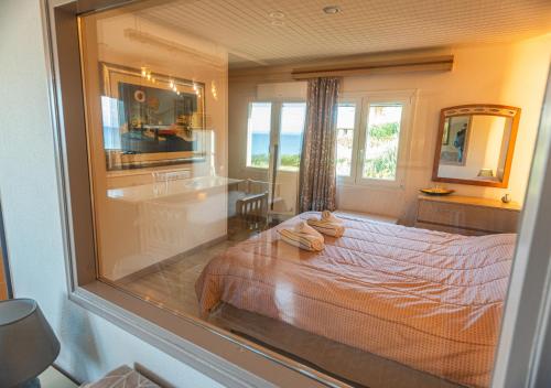 a bedroom with a bed and a large window at Aegean Bliss Residences - Karfas in Karfas