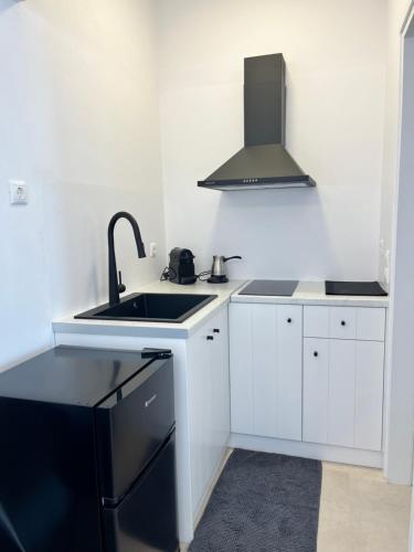 a white kitchen with a sink and a stove at Aeolian Breeze 3 in Tinos