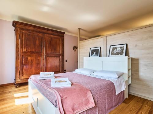 a bedroom with a large bed with a wooden cabinet at Casa Vittoria-Relax tra Lago di Garda e Verona in Custoza