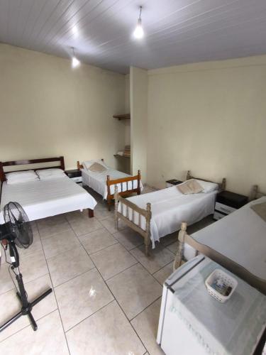 a room with three beds and a camera in it at Pousada Veadeiros - Alto Paraiso de Goiás in Alto Paraíso de Goiás