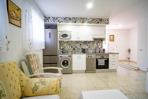a kitchen with a couch and a stove top oven at apartamento privado en un chalet 3 in L’Alfàs del Pi