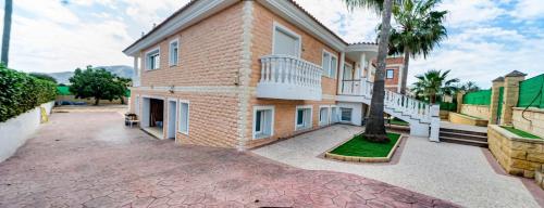 a large brick house with a courtyard at apartamento privado en un chalet 3 in L’Alfàs del Pi