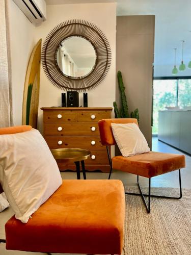 - une chambre avec un miroir, une chaise et une commode dans l'établissement villa dans un écrin de verdure, à Saint-Quentin-la-Poterie