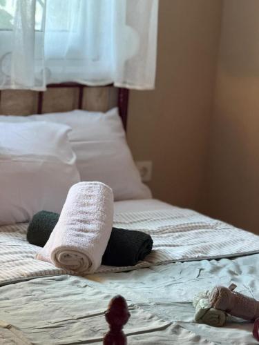 a bed with towels on top of it at Elenora house in Nea Kalikratia