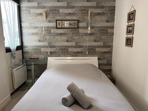 - une chambre dotée d'un lit avec un mur en bois dans l'établissement ღ La Kaz - Port des Minimes, Piscine, Parking & Wi-Fi, à La Rochelle