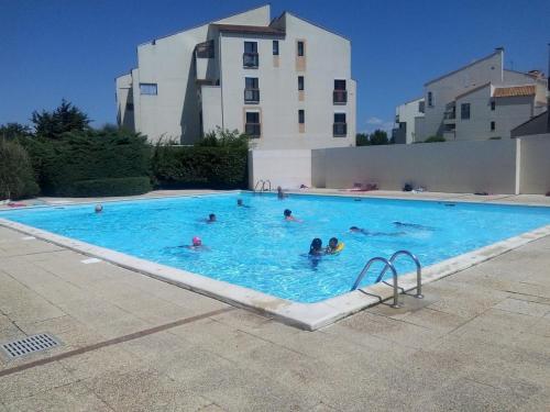 un groupe de personnes se baignant dans une grande piscine dans l'établissement ღ La Kaz - Port des Minimes, Piscine, Parking & Wi-Fi, à La Rochelle
