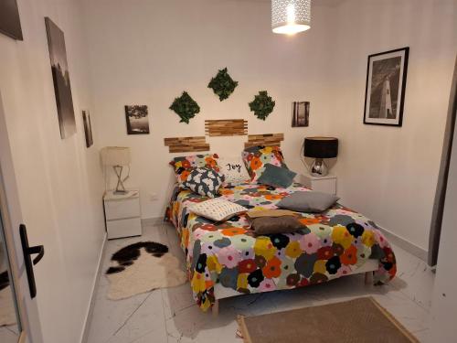 une chambre avec un lit avec une couette colorée dans l'établissement Zen et cosy, à Marseille