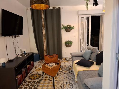 un salon avec un canapé et une télévision dans l'établissement Zen et cosy, à Marseille