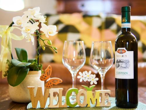 a bottle of wine and two wine glasses on a table at Casa Vittoria-Relax tra Lago di Garda e Verona in Custoza