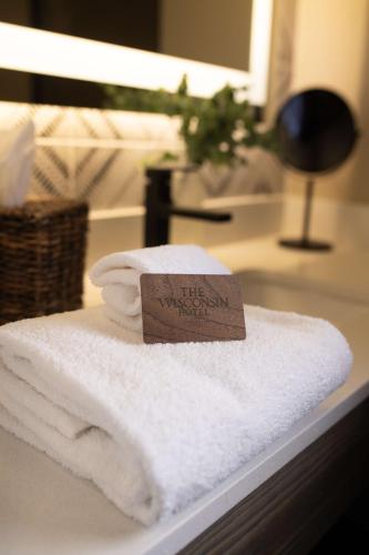 a pile of towels on a counter with a sign on it at The Wisconsin Hotel & Conference Center in Wisconsin Dells