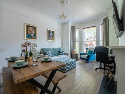 a living room with a table and a couch at Tettenhall Lodge Gardens in Wolverhampton
