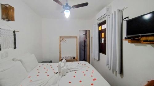 a bedroom with a bed and a ceiling fan at Pousada Du’Forte in Praia do Forte