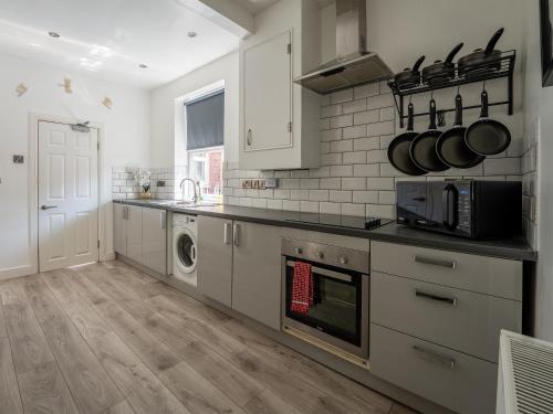 a kitchen with a sink and a stove top oven at Tettenhall Lodge Gardens in Wolverhampton