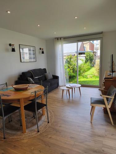 un salon avec une table et un canapé dans l'établissement Jolie Maison en Bord de Mer à Pourville, à Hautot-sur-Mer