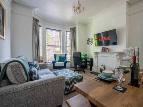 a living room with a couch and a table at Tettenhall Lodge Gardens in Wolverhampton