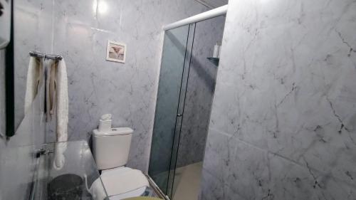 a bathroom with a toilet and a glass shower at Pousada Du’Forte in Praia do Forte