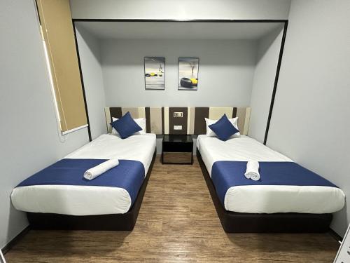 two beds in a room with blue and white pillows at Amazing Seaview Duplex George Town Maritime Suites 07 in George Town