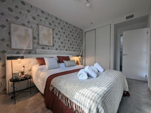 Un dormitorio con una cama grande con toallas. en Xava Dreams Aire, en Villacosta