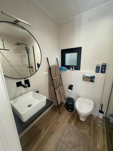 a bathroom with a sink and a toilet and a mirror at Tiny house in São Brás de Alportel