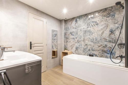 une salle de bain avec une baignoire et un lavabo dans l'établissement Appartement en bord de mer avec piscine - Cannes, à Cannes