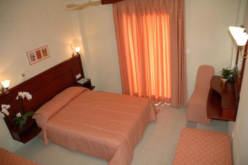 a hotel room with a bed and a window at Loutra Beach Hotel in Agia Paraskevi
