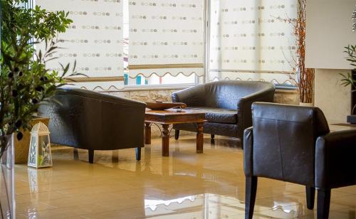 a living room with two leather chairs and a table at Loutra Beach Hotel in Agia Paraskevi