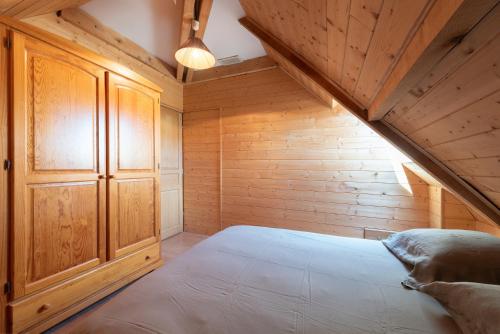 a bedroom with a bed in a wooden attic at Maison Zen dans les Pyrénées in Coarraze