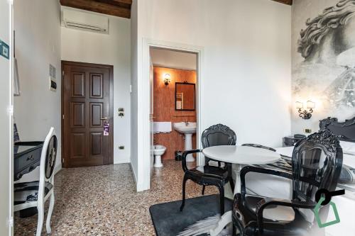 a room with a table and chairs and a bathroom at HOTIDAY Room Collection - Dolo in Dolo