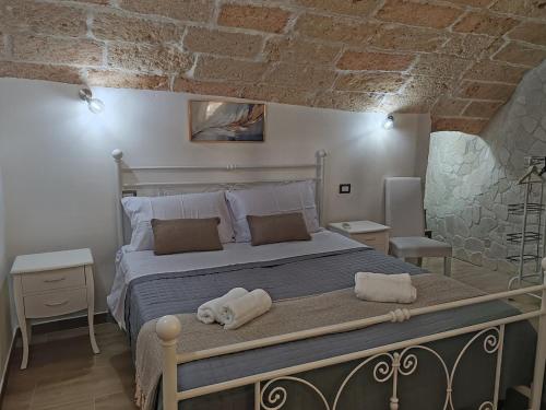 莱切Dimora Bianca 64的卧室里有一张大床，床上铺着毛巾。