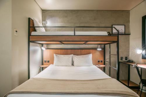 a bedroom with two bunk beds with white sheets at ibis Sao Luis in São Luís