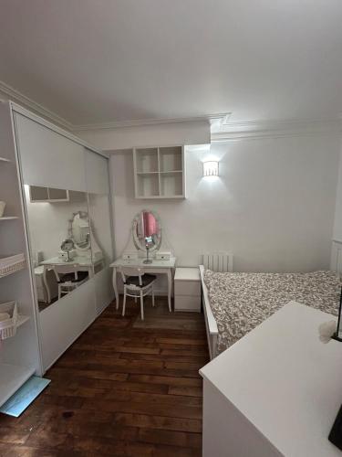 une chambre avec un lit, une table et un miroir dans l'établissement Charme parisien - Central et Cosy - 2 pièces vers Opéra, à Paris