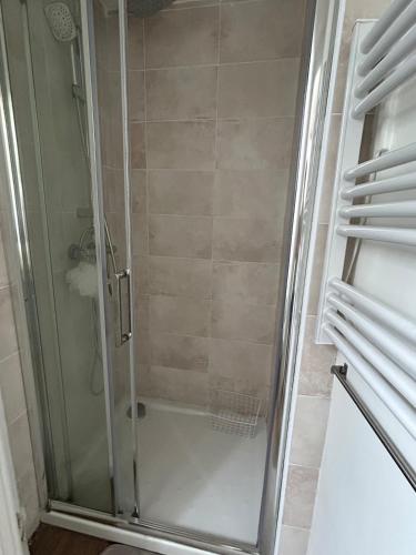 une douche avec une porte vitrée dans une salle de bain dans l'établissement Charme parisien - Central et Cosy - 2 pièces vers Opéra, à Paris