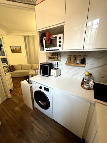 une cuisine avec un lave-linge et un micro-ondes dans l'établissement Charme parisien - Central et Cosy - 2 pièces vers Opéra, à Paris