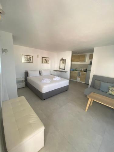 a large bedroom with a bed and a couch at mykonos 1001 in Agios Stefanos